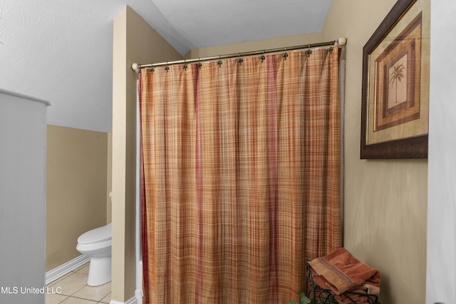 bathroom featuring tile patterned flooring, toilet, and curtained shower