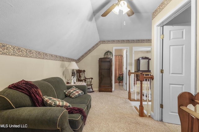 living area with light colored carpet, a ceiling fan, vaulted ceiling, and baseboards