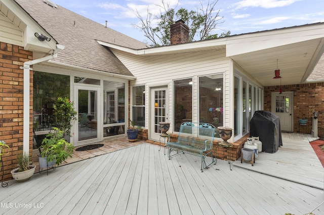 wooden terrace featuring grilling area and a sunroom