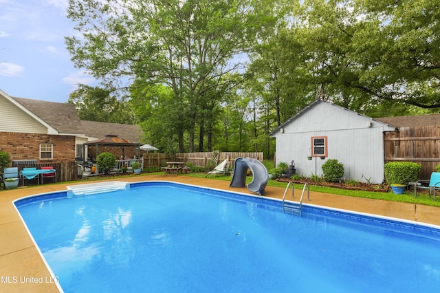 view of pool with a gazebo, a fenced backyard, an outbuilding, and a grill