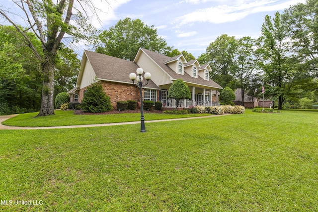 cape cod home featuring brick siding, a front yard, and roof with shingles