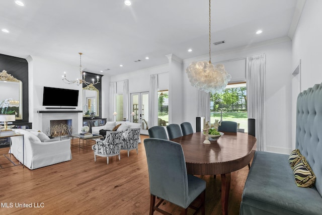 323 Penrose Pl, Madison, MS 39110 - dining area with a chandelier, wood finished floors, crown molding, recessed lighting, and a fireplace