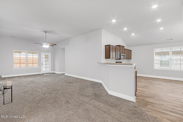 unfurnished living room featuring hardwood / wood-style floors, vaulted ceiling, and ceiling fan