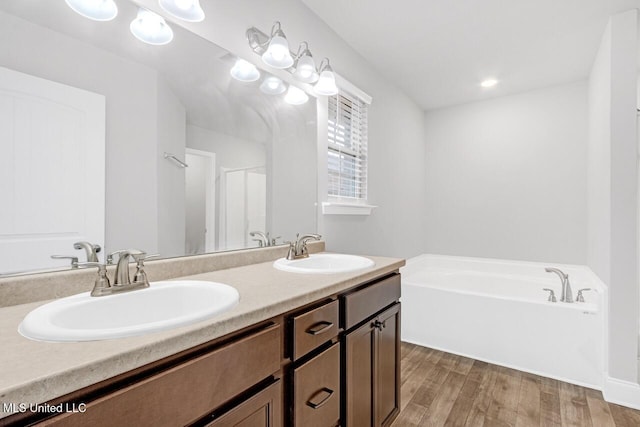 bathroom with a bathtub, vanity, and hardwood / wood-style flooring