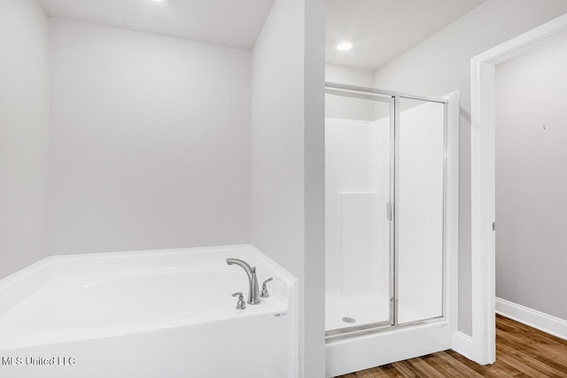 bathroom featuring hardwood / wood-style floors and separate shower and tub