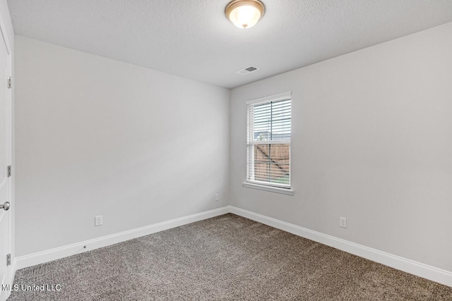 spare room with a textured ceiling and carpet