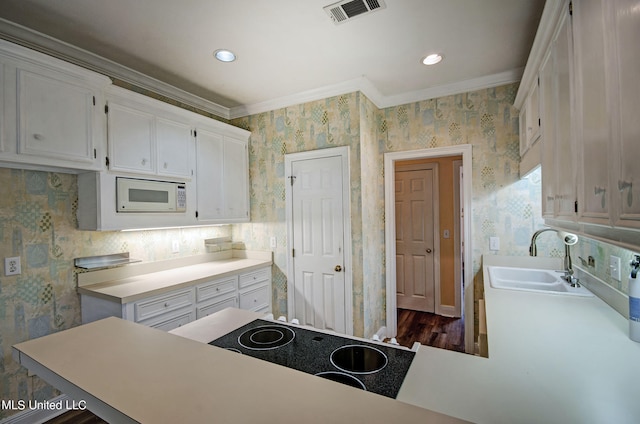 kitchen featuring white microwave, ornamental molding, sink, white cabinets, and dark hardwood / wood-style flooring