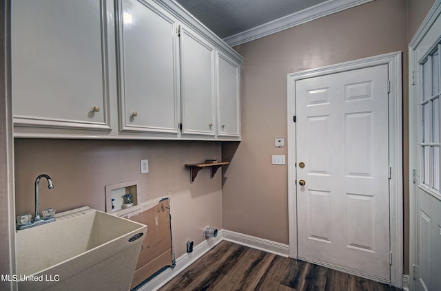 clothes washing area featuring dark hardwood / wood-style floors, hookup for a washing machine, sink, crown molding, and cabinets