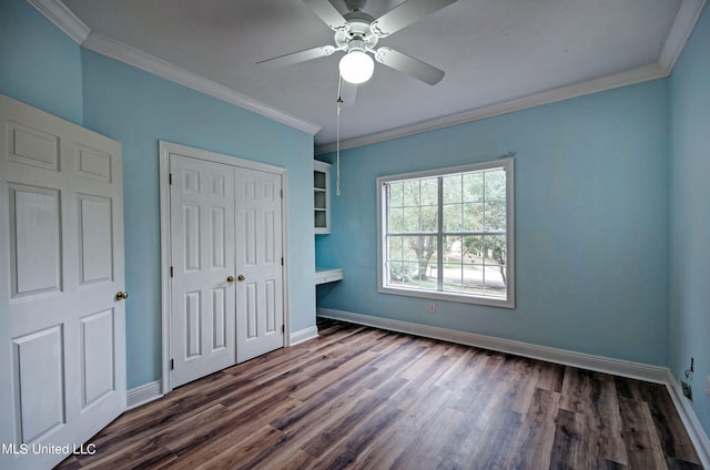 unfurnished bedroom featuring a closet, crown molding, ceiling fan, and dark hardwood / wood-style flooring