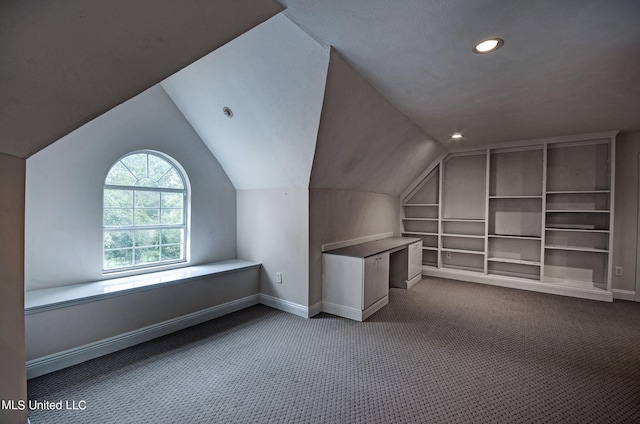 bonus room with lofted ceiling, built in shelves, and carpet floors