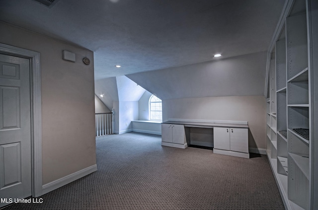 bonus room featuring built in desk, carpet, and lofted ceiling