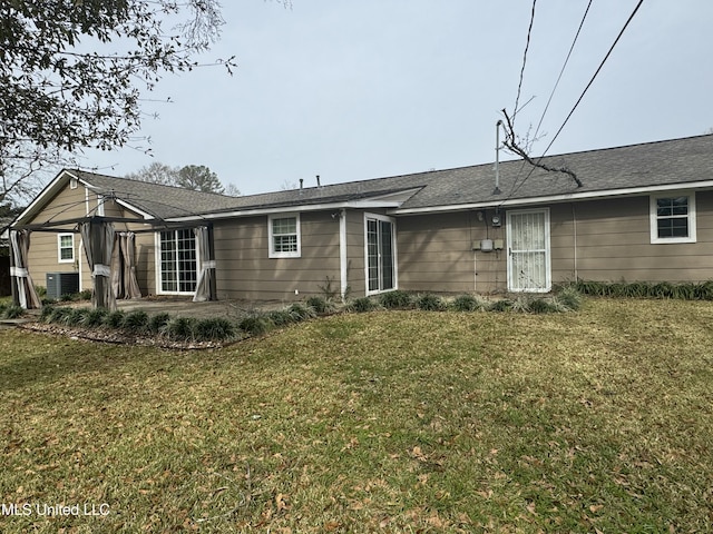 back of property with central AC unit, a lawn, and a patio