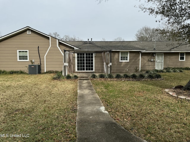 ranch-style house featuring cooling unit and a front lawn