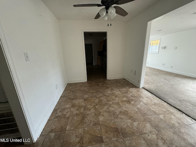 spare room featuring ceiling fan and carpet