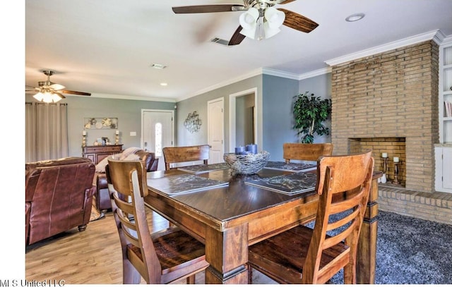 506 Loposser Ave, Gulfport, MS 39507 - dining room featuring ceiling fan, a brick fireplace, crown molding, light wood finished floors, and recessed lighting