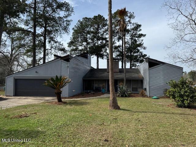 view of front of house featuring an attached garage, a front lawn, and concrete driveway