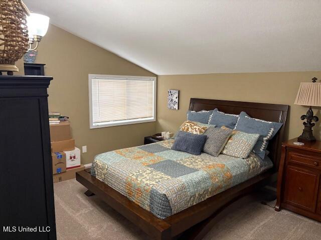 bedroom with vaulted ceiling and light colored carpet