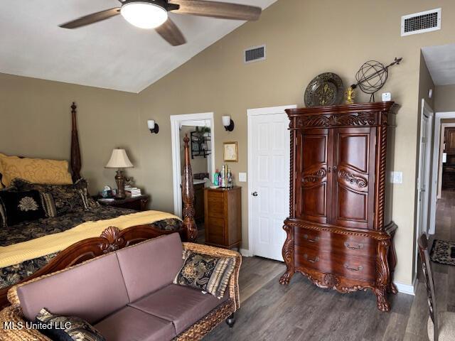 bedroom with ceiling fan, visible vents, vaulted ceiling with beams, and wood finished floors