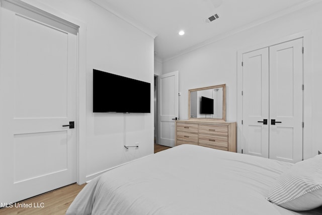 bedroom featuring wood finished floors, ornamental molding, a closet, and recessed lighting