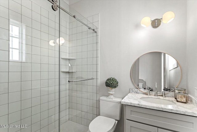 bathroom featuring toilet, tiled shower, and vanity