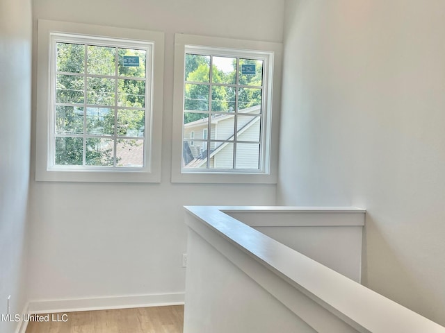 hallway featuring baseboards and wood finished floors