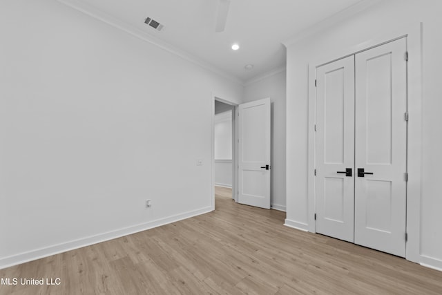 unfurnished bedroom featuring ornamental molding, light wood-type flooring, baseboards, a closet, and recessed lighting