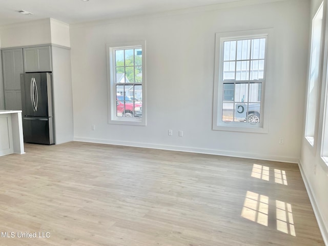 interior space featuring ornamental molding and light wood-type flooring