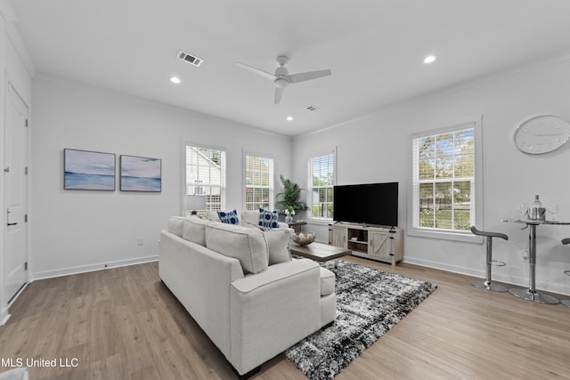 living room featuring crown molding, light wood-type flooring, a ceiling fan, baseboards, and recessed lighting
