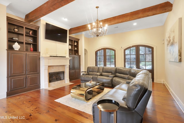 living room with beam ceiling, dark hardwood / wood-style flooring, an inviting chandelier, and french doors