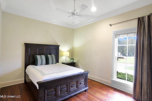 bedroom featuring hardwood / wood-style flooring, ceiling fan, crown molding, and multiple windows