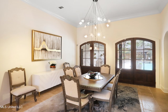 tiled dining room featuring french doors, ornamental molding, and a notable chandelier