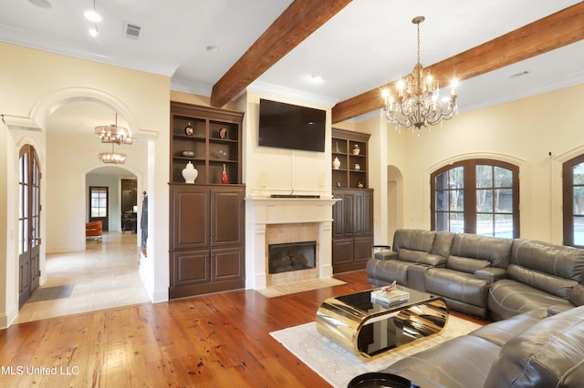 living room featuring a chandelier, beam ceiling, french doors, and hardwood / wood-style floors