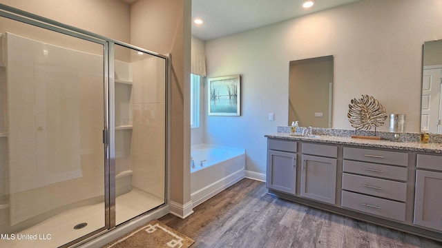 bathroom featuring vanity, wood-type flooring, and separate shower and tub