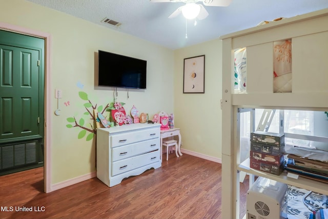 bedroom with visible vents, baseboards, a textured ceiling, and wood finished floors