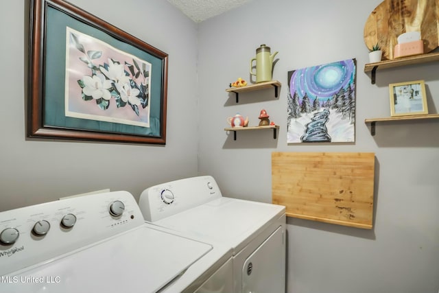 laundry room with a textured ceiling, washing machine and dryer, and laundry area