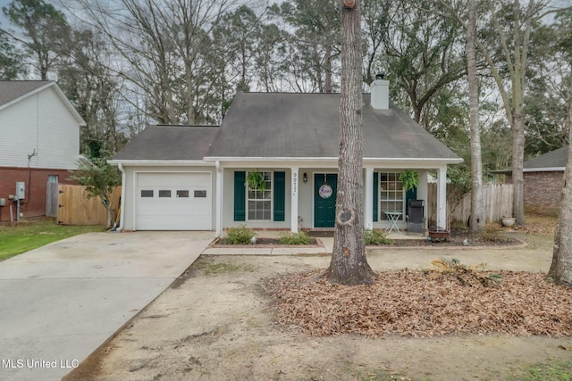 view of front facade with fence, covered porch, a chimney, a garage, and driveway