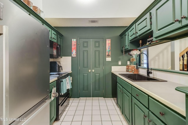 kitchen with green cabinets, black appliances, visible vents, and a sink