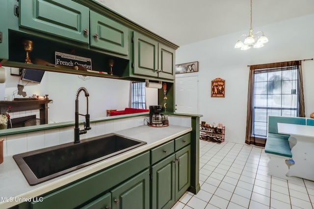 kitchen with a sink, a fireplace, light countertops, green cabinetry, and light tile patterned floors