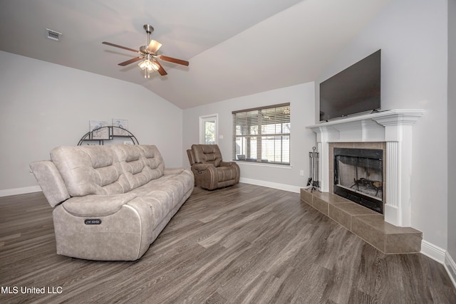 living room featuring wood finished floors, a ceiling fan, visible vents, lofted ceiling, and a tile fireplace