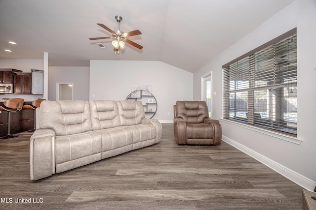 living area featuring baseboards, lofted ceiling, ceiling fan, and dark wood-style flooring