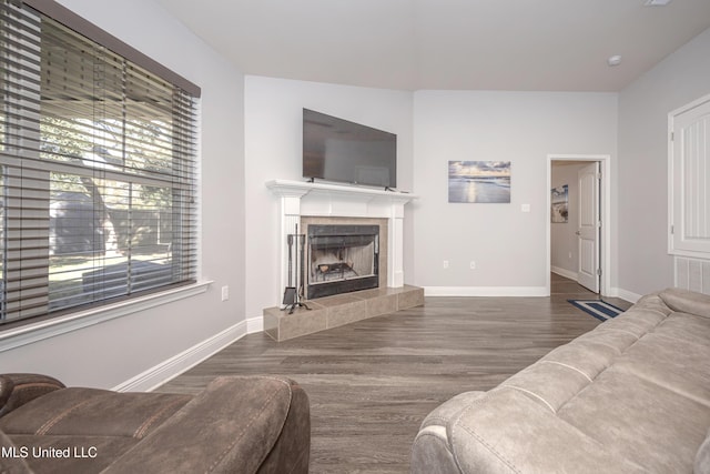 living area with wood finished floors, a fireplace, baseboards, and visible vents