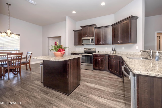 kitchen featuring wood finished floors, a sink, dark brown cabinetry, appliances with stainless steel finishes, and a notable chandelier