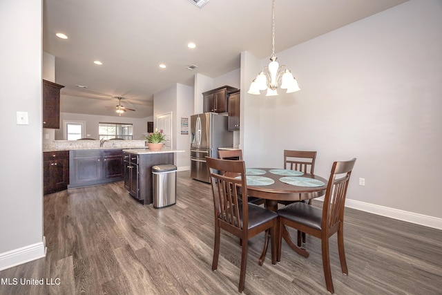 dining space with ceiling fan with notable chandelier, recessed lighting, dark wood-style floors, and baseboards