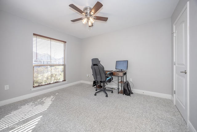 carpeted office featuring baseboards and a ceiling fan