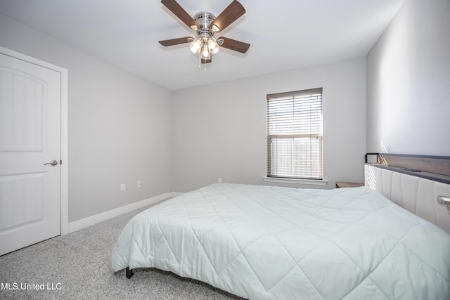 carpeted bedroom with ceiling fan and baseboards