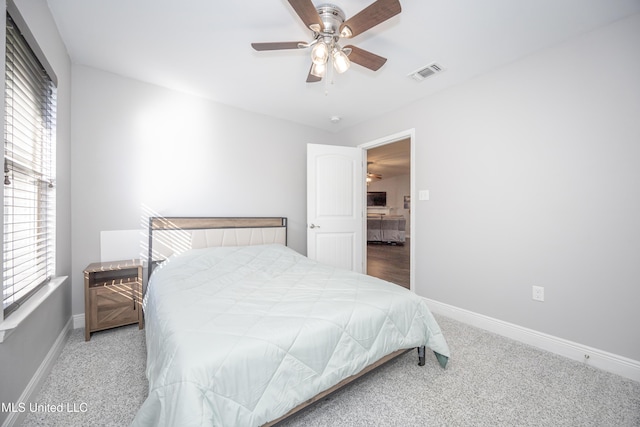 carpeted bedroom with a ceiling fan, baseboards, and visible vents