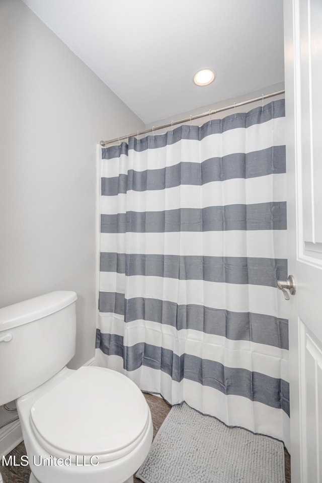 bathroom with recessed lighting, curtained shower, and toilet