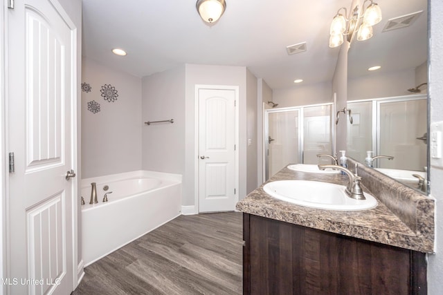 bathroom with visible vents, a shower stall, a sink, and wood finished floors