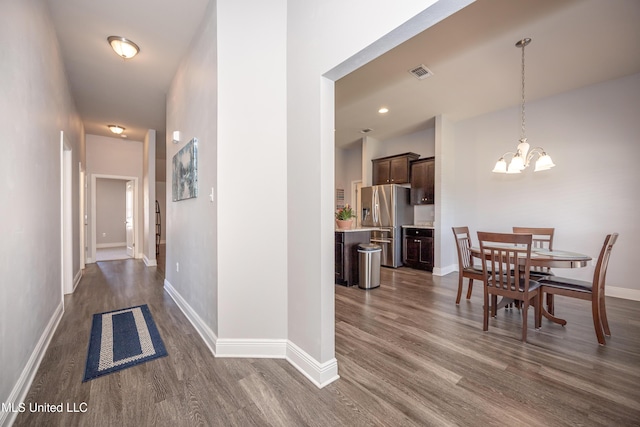 hallway with visible vents, baseboards, recessed lighting, dark wood-type flooring, and a notable chandelier