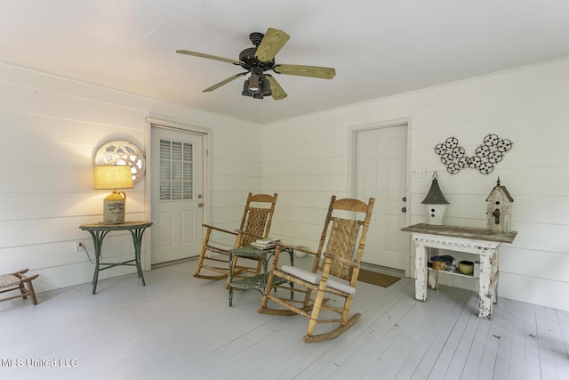 sitting room featuring wood-type flooring and ceiling fan